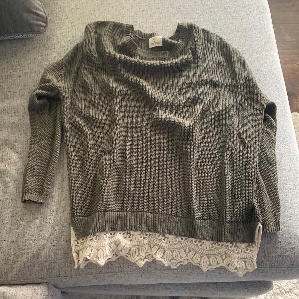 Green sweater with lace detailing at the hem